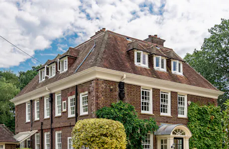 Large traditional red brick house with white sash windows.