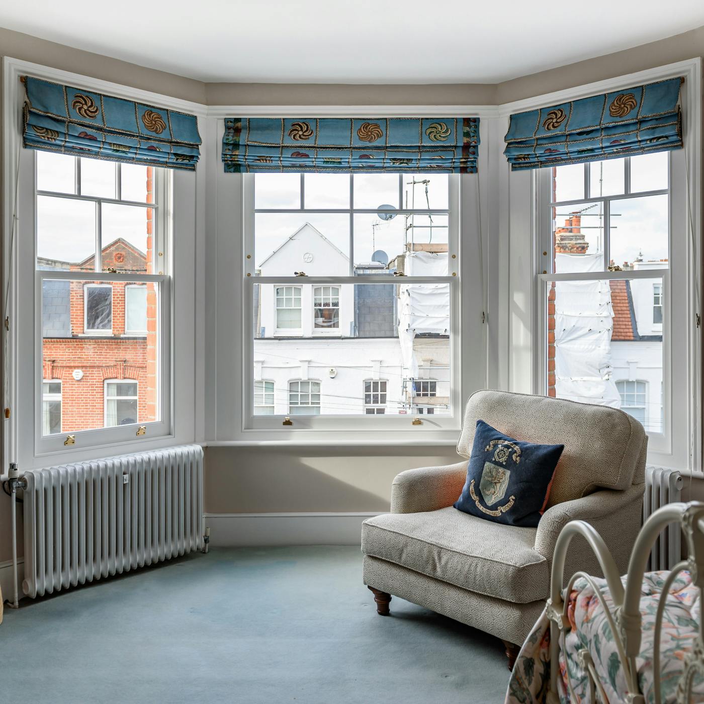 bay edwardian sash windows taken from inside with a rocking chair before london street